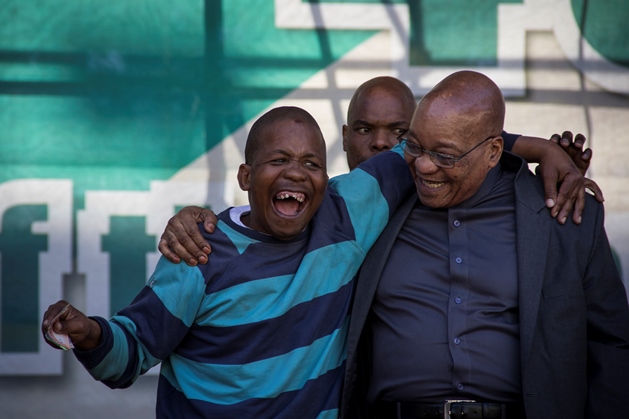 Collin Thauke (32), a regular at African National Congress (ANC) events, gets requested on stage by President Jacob Zuma after he danced and sang at the foot of the stage. Presidential security is ever vigilant as Tahuke embraces Zuma heartily.