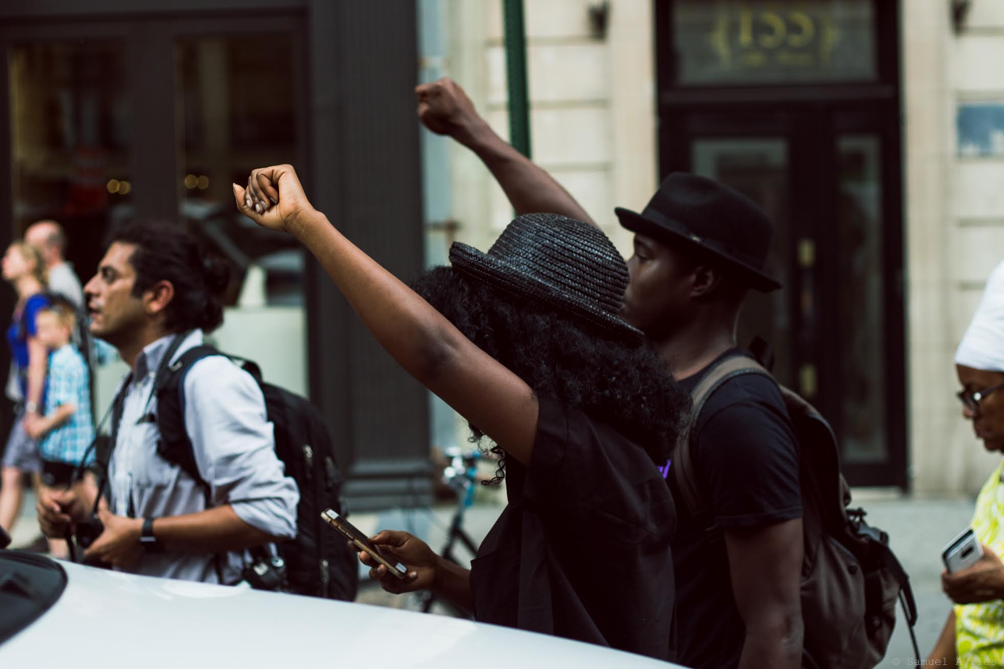 Pair marches in the street during Thursday July 7th, 2016 police brutality protests in Manhattan, New York. The protest is in response to the two recent shootings of black men by the police.